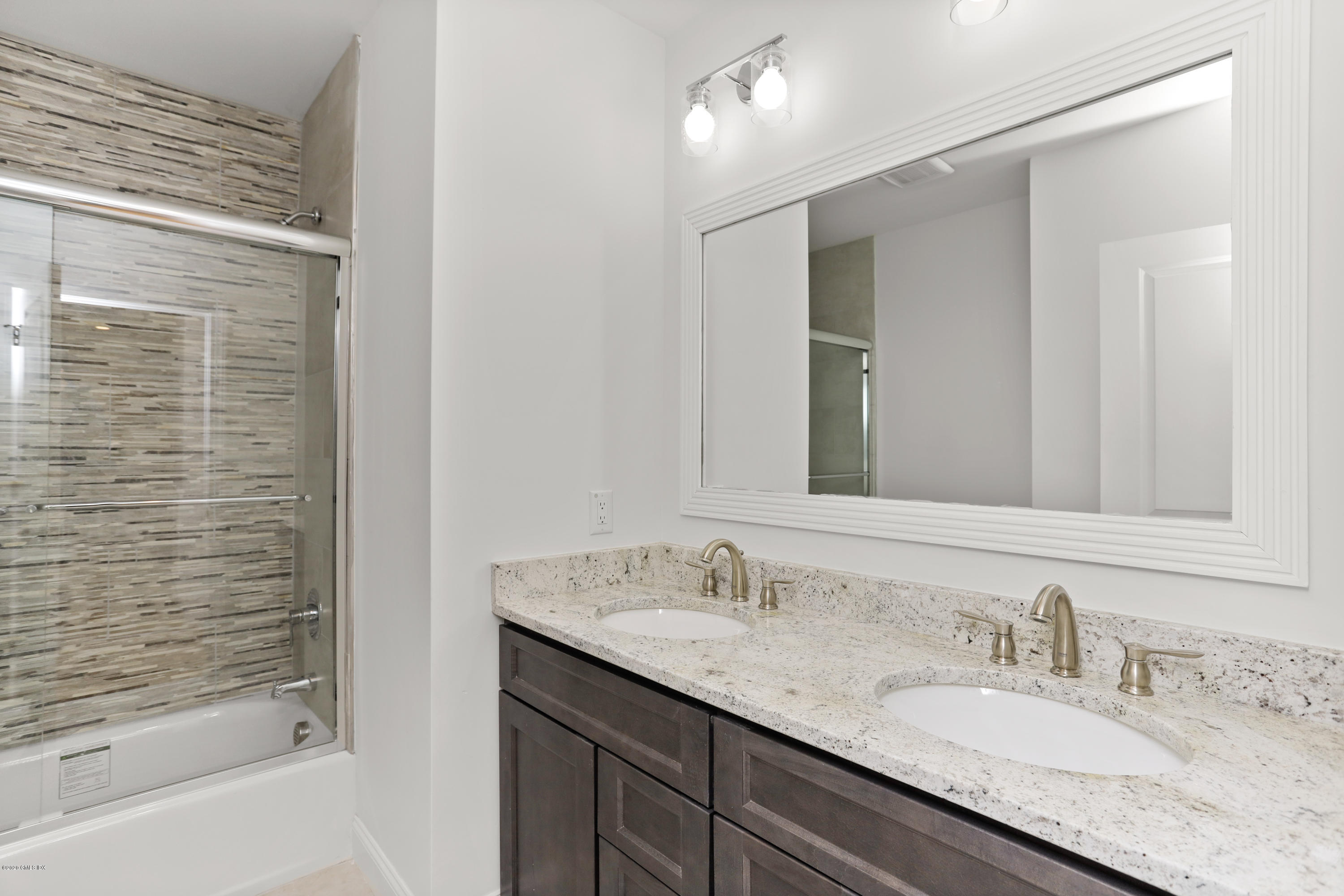 125 Hamilton Avenue, Unit 2 Greenwich, CT 06830 - Photo 12 of 20 a bathroom with a granite countertop sink and a mirror