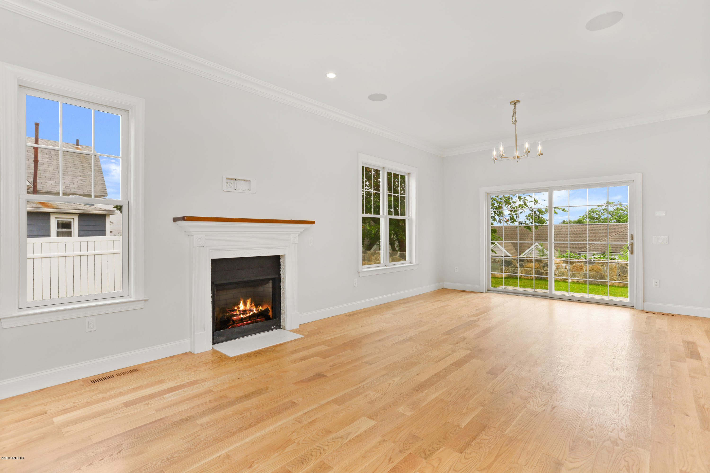 125 Hamilton Avenue, Unit 2 Greenwich, CT 06830 - Photo 6 of 20 a view of an empty room with wooden floor fireplace and a window