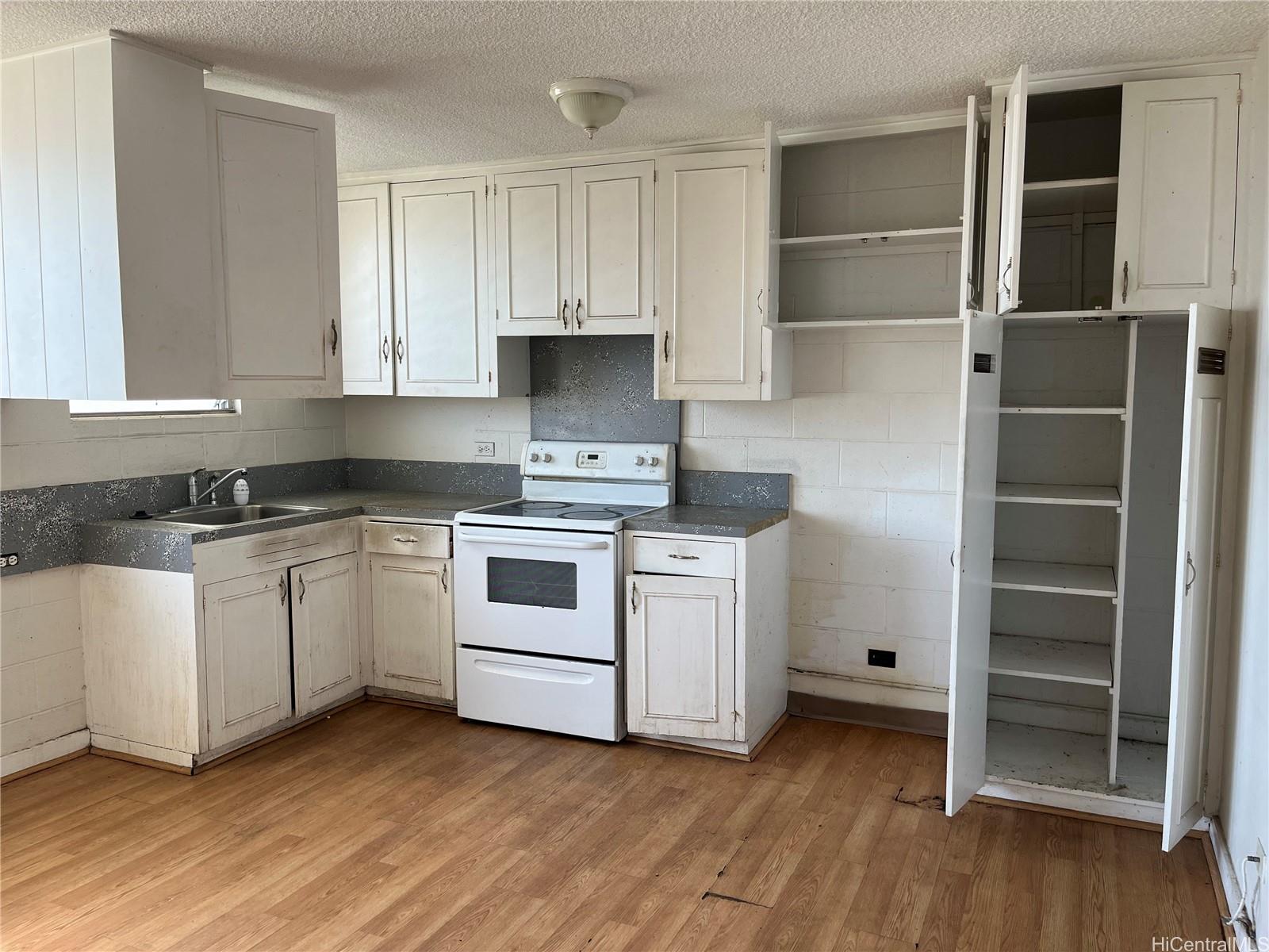 1516 Emerson Street, Unit 104 Honolulu, HI 96813 - Photo 3 of 9 a kitchen with white cabinets and white appliances