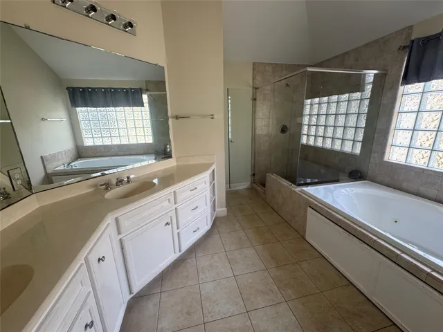 a spacious bathroom with a double vanity sink a mirror and a bathtub