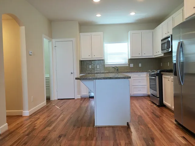a kitchen with wooden floors and refrigerator