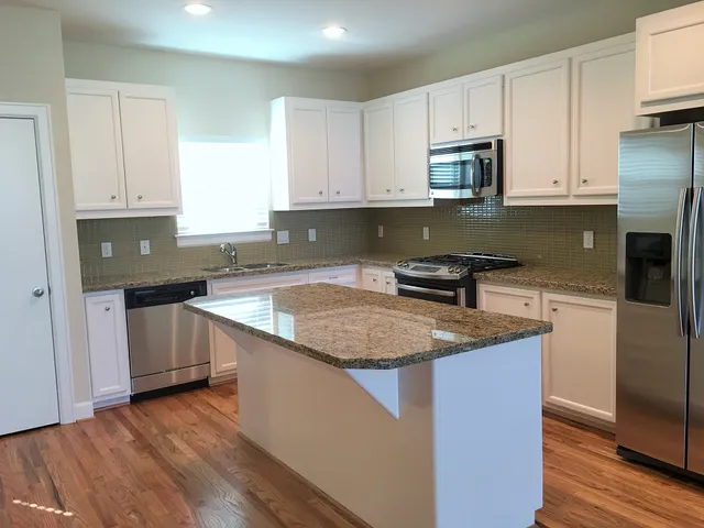 a kitchen with granite countertop a sink stove and cabinets