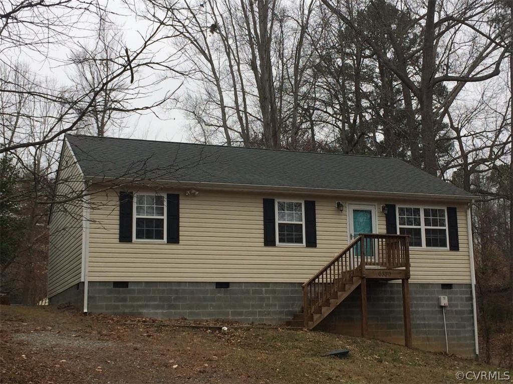 a backyard of a house with barbeque oven and table under a large tree