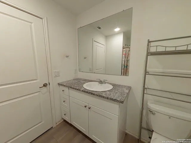 a bathroom with a granite countertop sink and a mirror