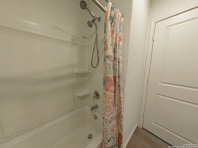a bathroom with a shower curtain and a bathtub