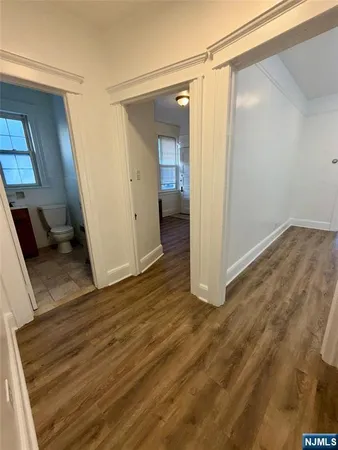 a view of a hallway with wooden floor and closet
