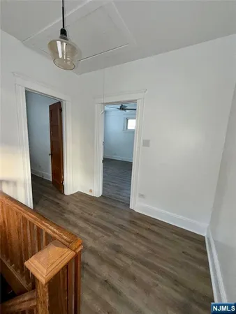 a view of a livingroom with wooden floor and staircase