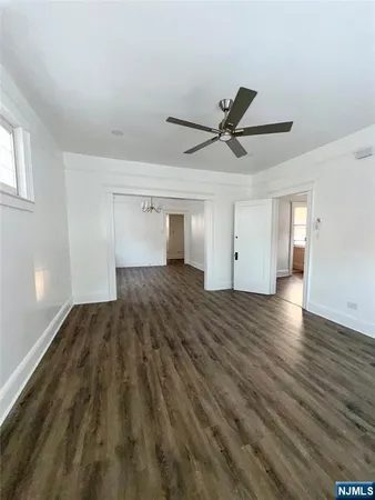a view of a big room with wooden floor and windows