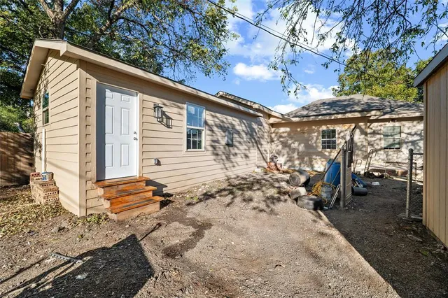 a kitchen with stainless steel appliances granite countertop a stove a refrigerator a sink dishwasher a dining table and chairs with wooden floor