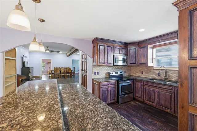 a kitchen with kitchen island granite countertop lots of counter top space and stainless steel appliances