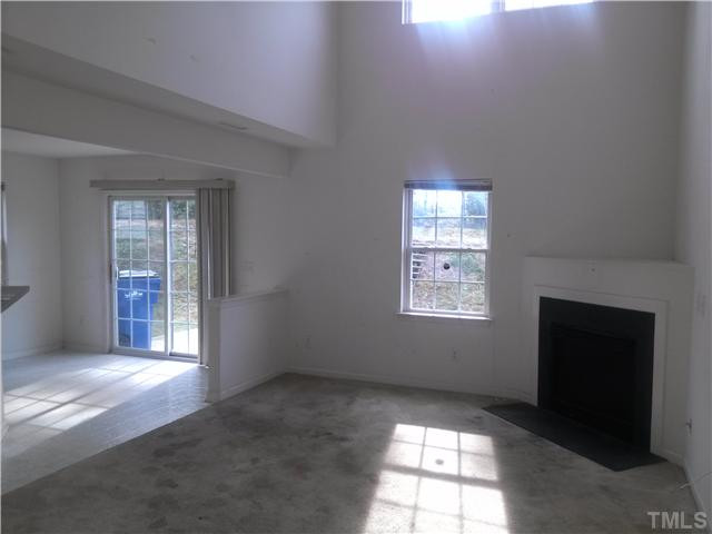 2817 Filbert Street Raleigh, NC 27610 - Photo 3 of 11 Living room has lots of sunlight courtesy of 2 story ceiling. *Carpet and walls needs some attention*