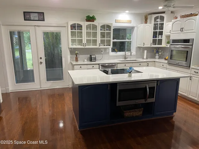 a kitchen with stainless steel appliances granite countertop a stove a sink and a microwave
