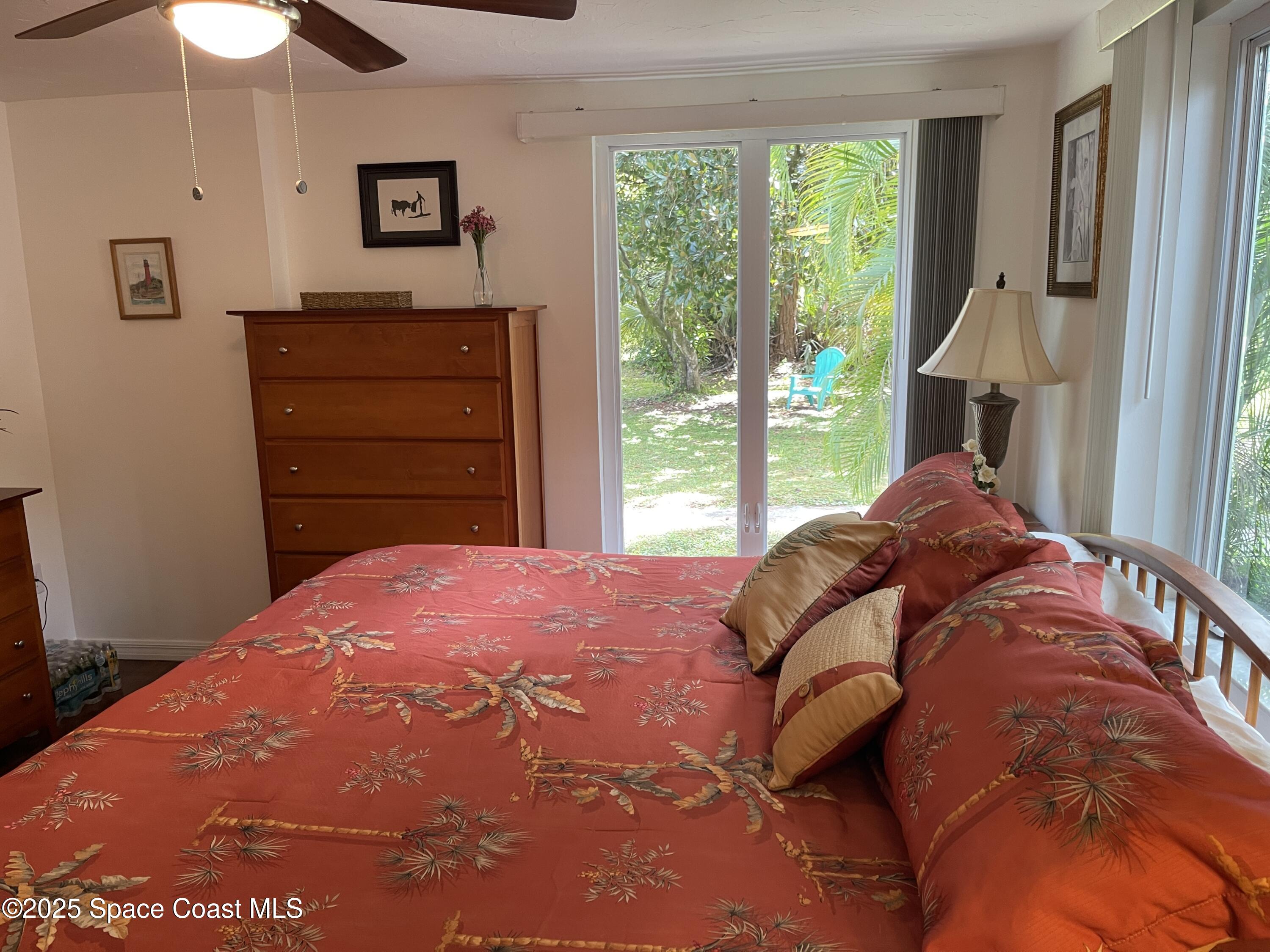 6910 Sheridan Road Melbourne, FL 32904 - Photo 16 of 38 a bedroom with a bed and a dresser
