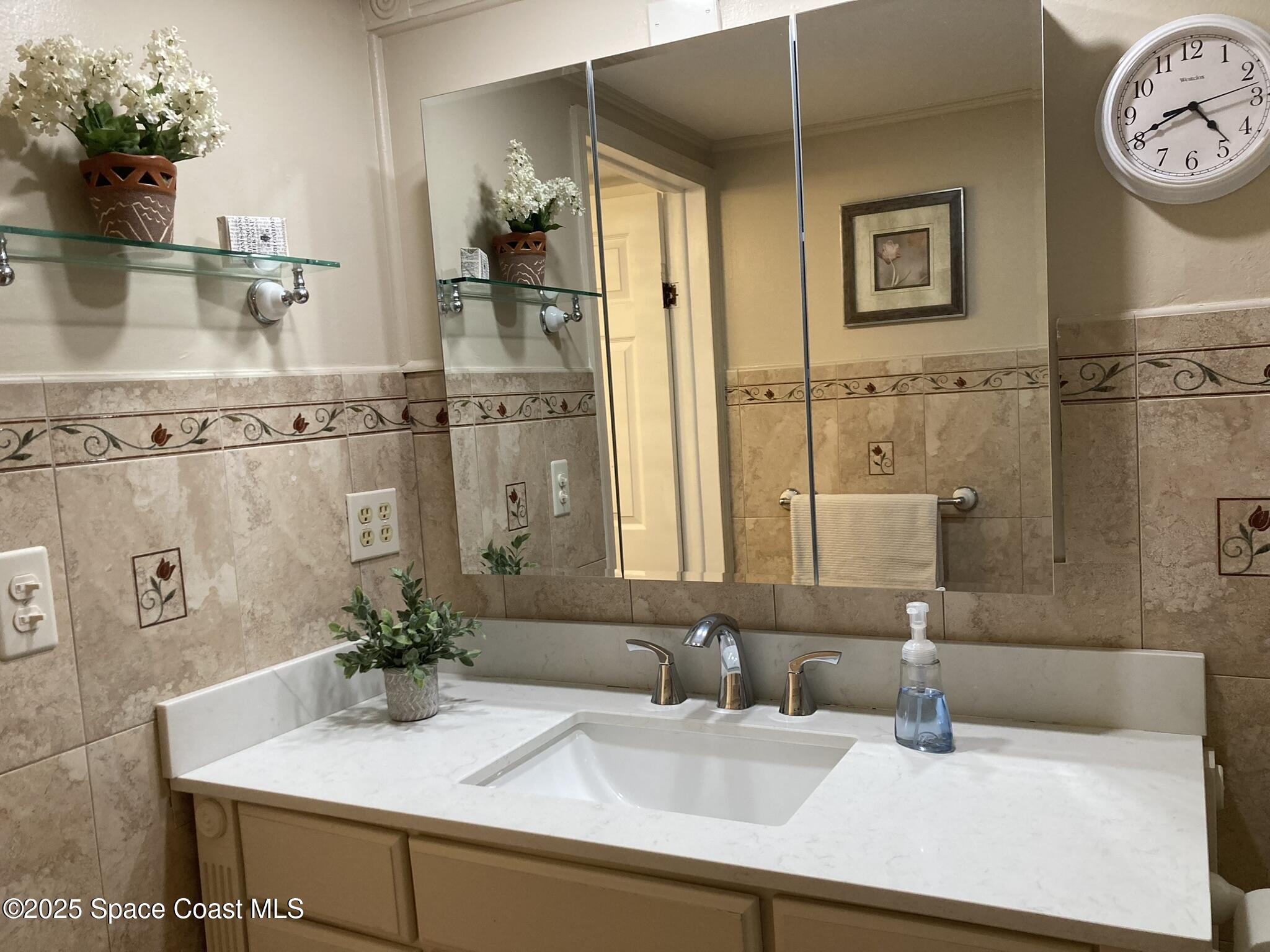 6910 Sheridan Road Melbourne, FL 32904 - Photo 17 of 38 a bathroom with a sink and a mirror