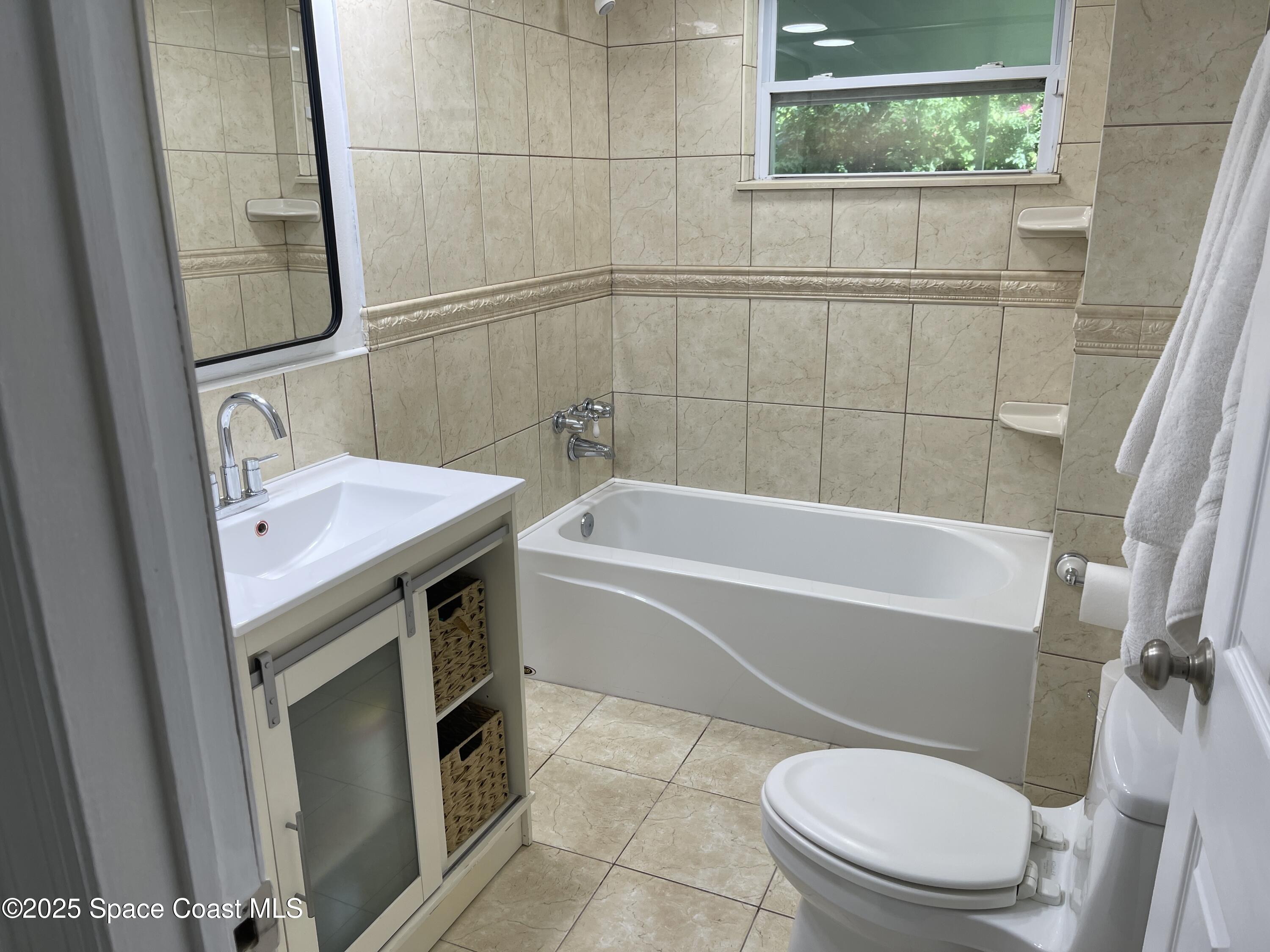 6910 Sheridan Road Melbourne, FL 32904 - Photo 28 of 38 a bathroom with a sink a toilet and bathtub