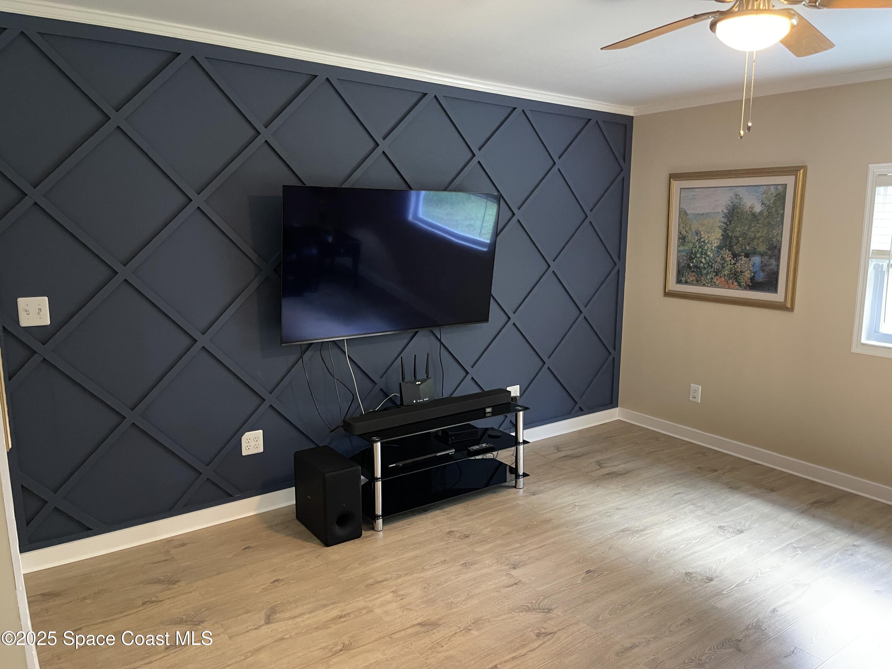 6910 Sheridan Road Melbourne, FL 32904 - Photo 29 of 38 a living room with furniture and a flat screen tv