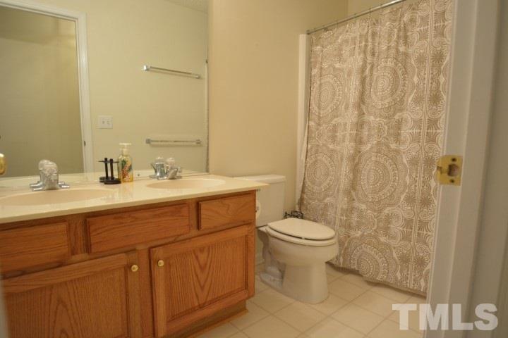 6208 Brielson Place Raleigh, NC 27616 - Photo 13 of 18 a bathroom with a sink a toilet and shower curtain