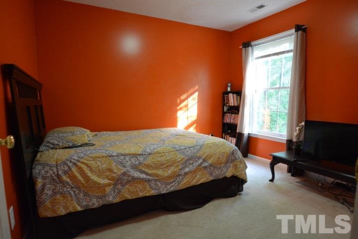 6208 Brielson Place Raleigh, NC 27616 - Photo 15 of 18 a bedroom with a bed tv and a window