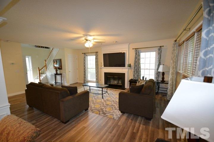 6208 Brielson Place Raleigh, NC 27616 - Photo 5 of 18 a living room with furniture a fireplace and a flat screen tv