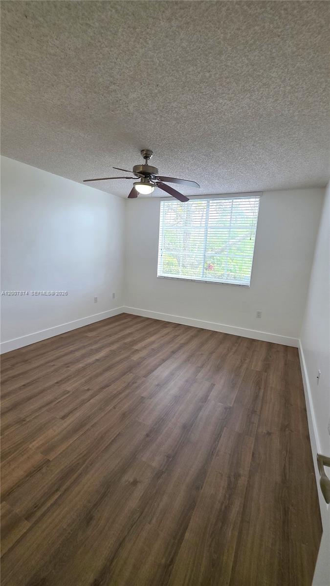 12136 St.Andrews Place, Unit 108 Miramar, FL 33025 - Photo 12 of 43 an empty room with wooden floor and windows