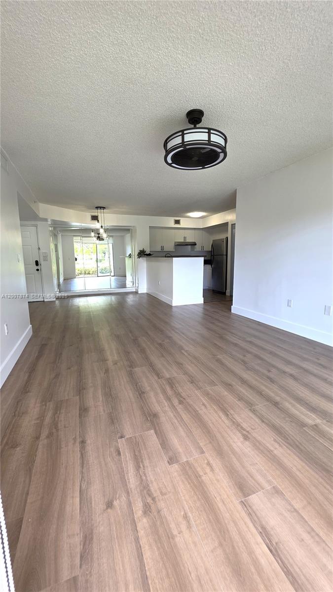 12136 St.Andrews Place, Unit 108 Miramar, FL 33025 - Photo 2 of 43 wooden floor in an empty room with a window