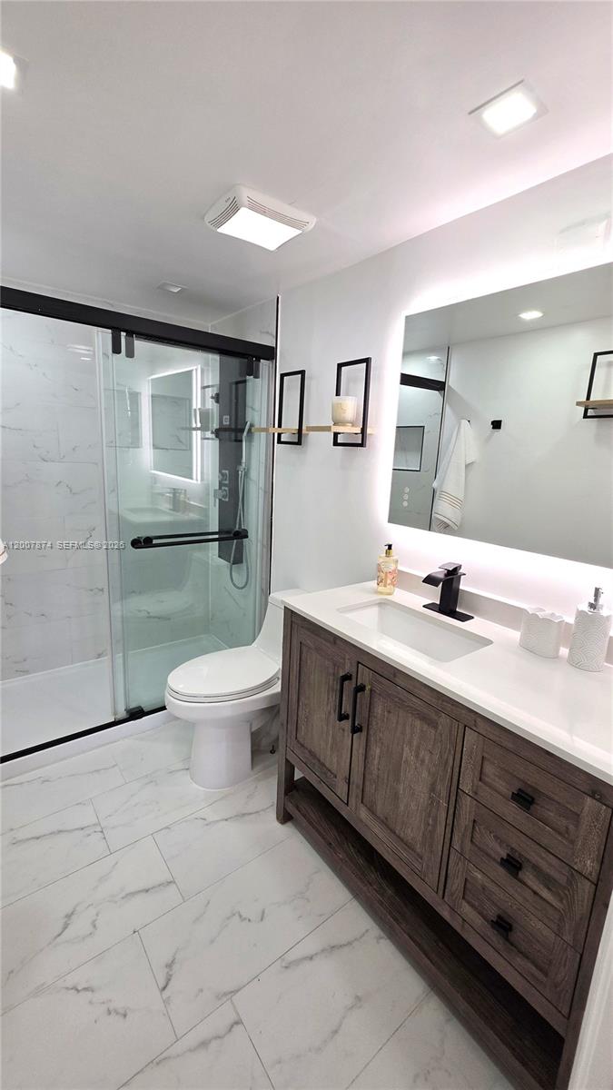 12136 St.Andrews Place, Unit 108 Miramar, FL 33025 - Photo 22 of 43 a spacious bathroom with a double vanity sink toilet and a mirror