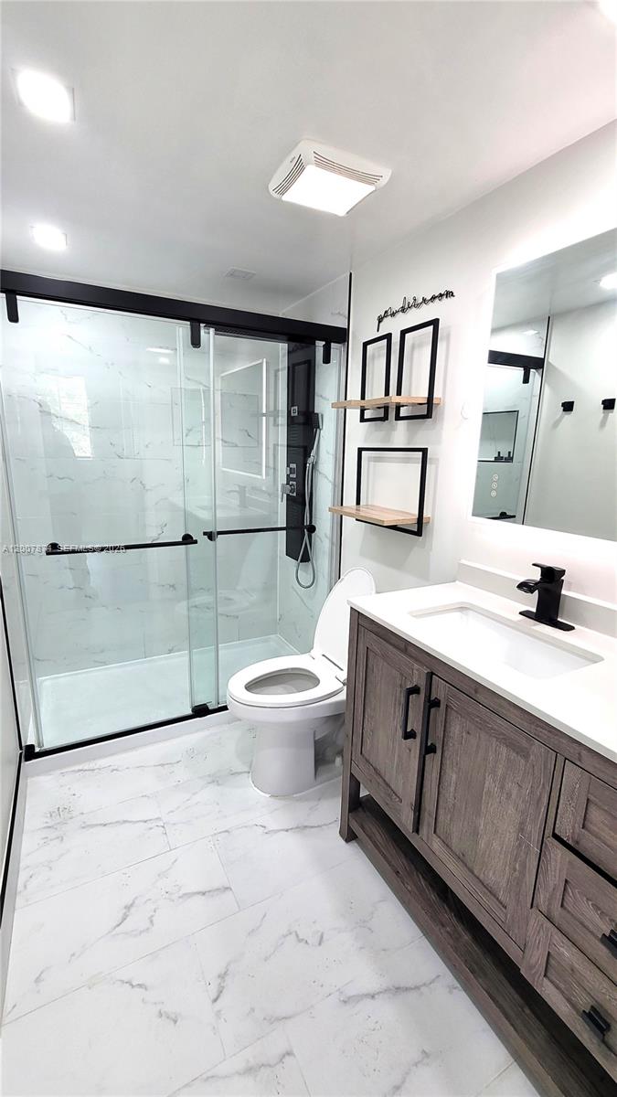 12136 St.Andrews Place, Unit 108 Miramar, FL 33025 - Photo 23 of 43 a bathroom with a double vanity sink toilet and shower
