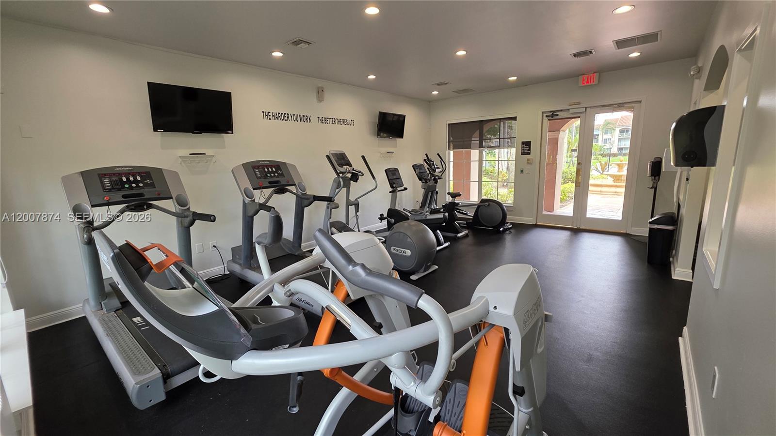 12136 St.Andrews Place, Unit 108 Miramar, FL 33025 - Photo 32 of 43 a room with gym equipment and a flat screen tv