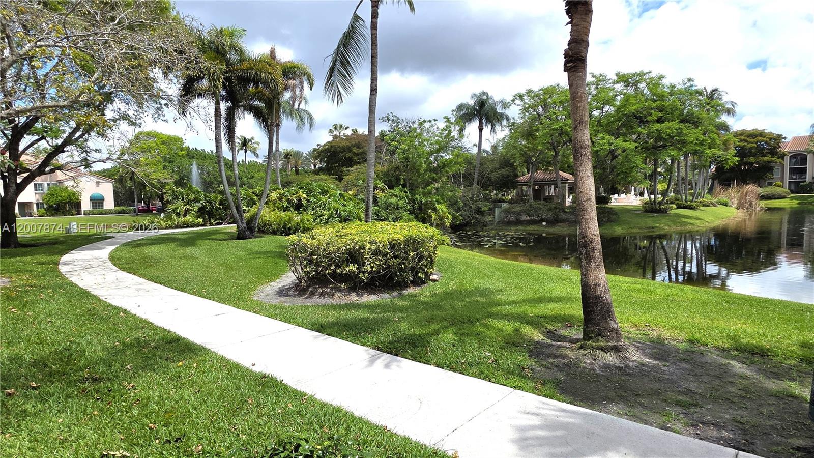 12136 St.Andrews Place, Unit 108 Miramar, FL 33025 - Photo 42 of 43 a view of a fountain in a yard with palm trees