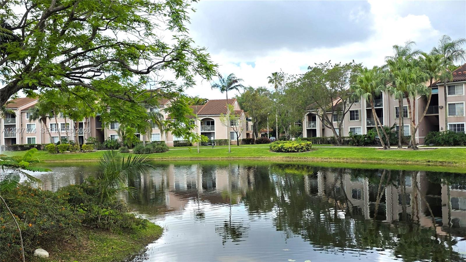 12136 St.Andrews Place, Unit 108 Miramar, FL 33025 - Photo 43 of 43 a lake view with a big yard plants and large trees