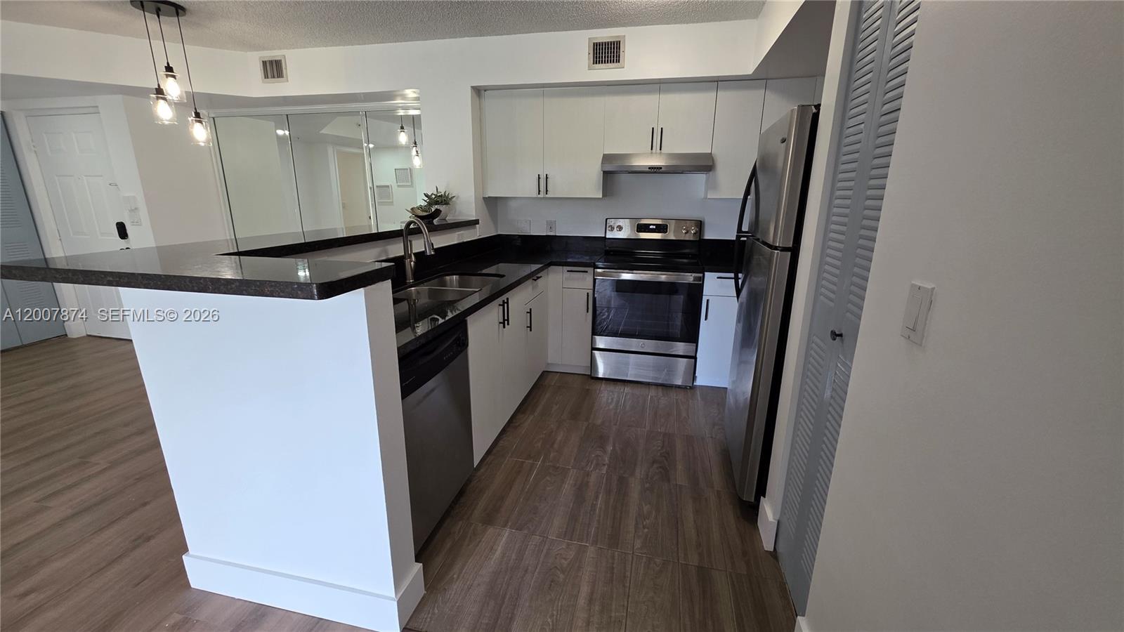 12136 St.Andrews Place, Unit 108 Miramar, FL 33025 - Photo 5 of 43 a kitchen with a sink and refrigerator