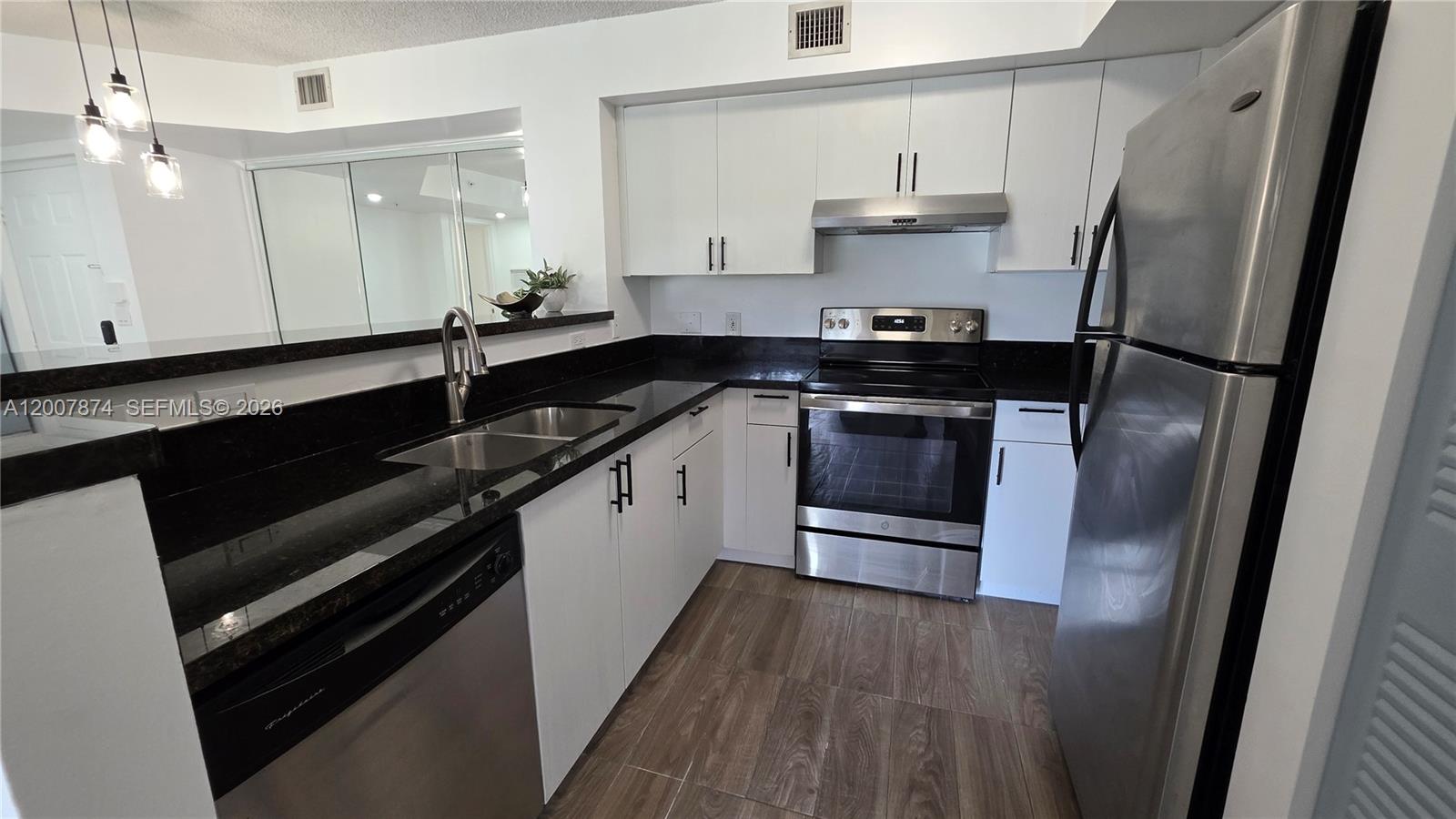 12136 St.Andrews Place, Unit 108 Miramar, FL 33025 - Photo 6 of 43 a kitchen with a sink and stainless steel appliances
