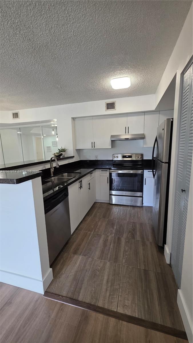 12136 St.Andrews Place, Unit 108 Miramar, FL 33025 - Photo 7 of 43 a kitchen with stainless steel appliances granite countertop a stove a sink dishwasher and a refrigerator