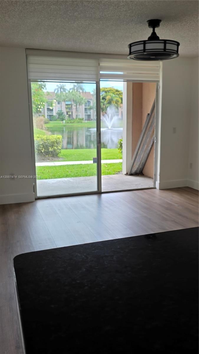 12136 St.Andrews Place, Unit 108 Miramar, FL 33025 - Photo 9 of 43 a view of an empty room with wooden floor and a floor to ceiling window