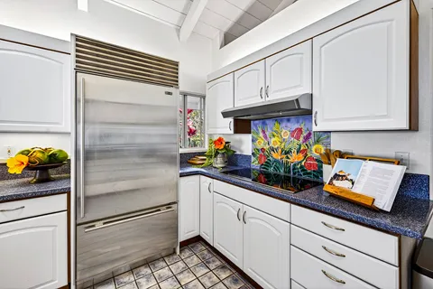 a kitchen with stainless steel appliances white cabinets and a refrigerator