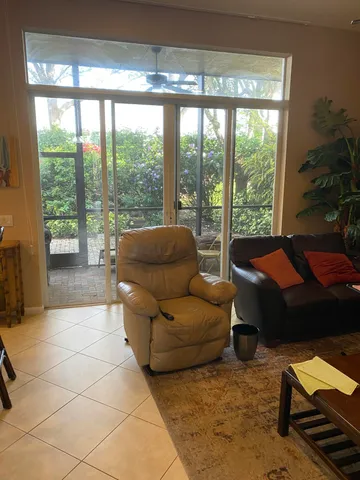a living room with furniture and a floor to ceiling window