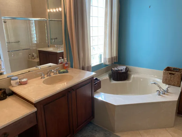 a bathroom with a tub sink and mirror