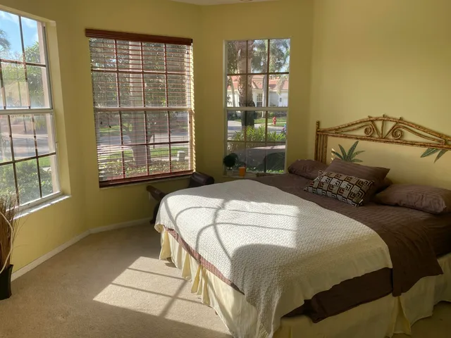 a bedroom with a bed and windows