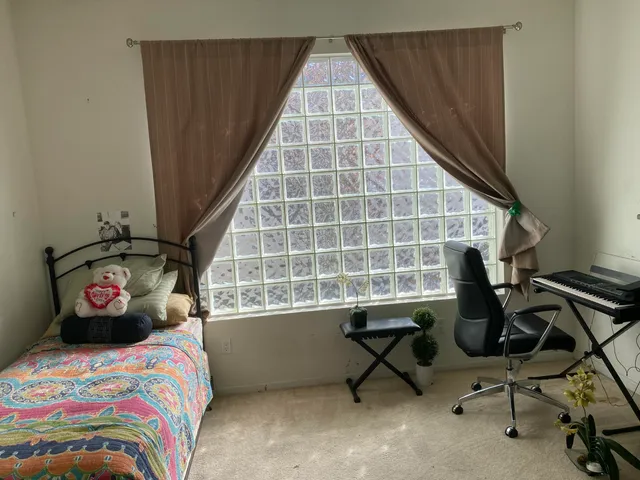 a bedroom with a bed and a desk next to a window