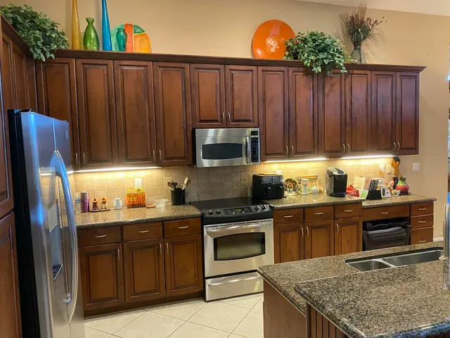 a kitchen with granite countertop wooden cabinets a stove and a stainless steel appliances