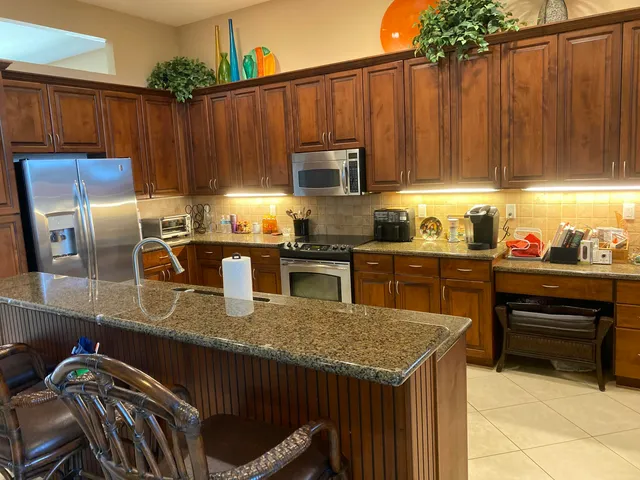 a kitchen with granite countertop a stove a sink and a refrigerator
