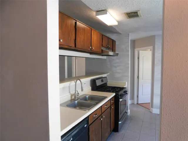 a kitchen with stainless steel appliances granite countertop a sink and a stove top oven
