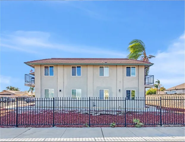 a view of a house with a wooden fence