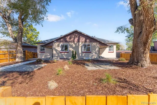 a view of a house with backyard and a tree