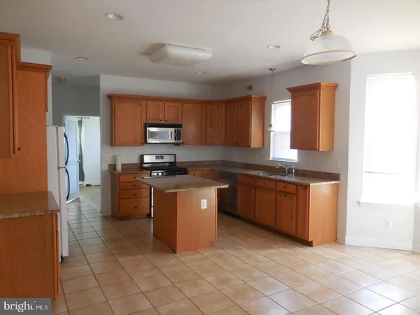 a kitchen with granite countertop a refrigerator and a sink