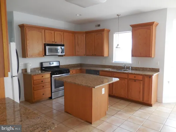 a kitchen with stainless steel appliances granite countertop a stove top oven a sink dishwasher and a refrigerator