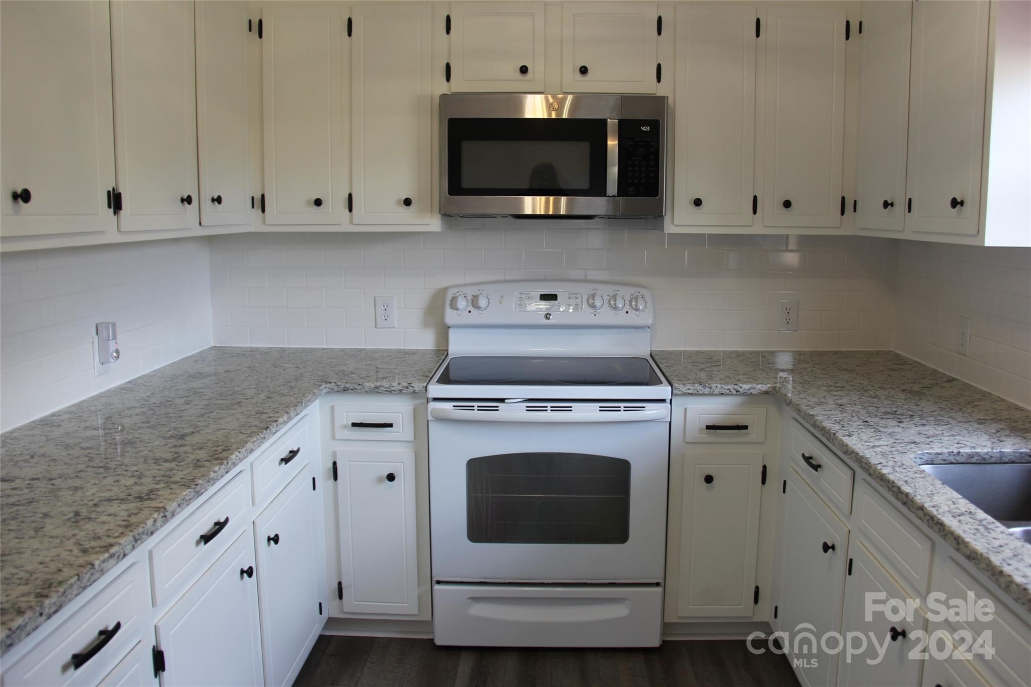 147 Sinclair Road Mooresville, NC 28115 - Photo 7 of 30 a kitchen with granite countertop white cabinets and a stove