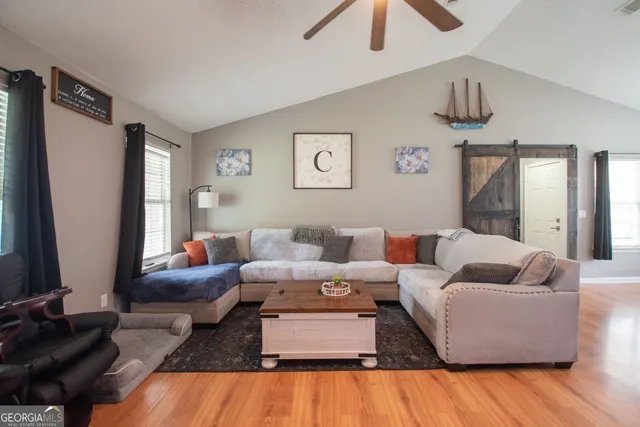 a living room with furniture and wooden floor