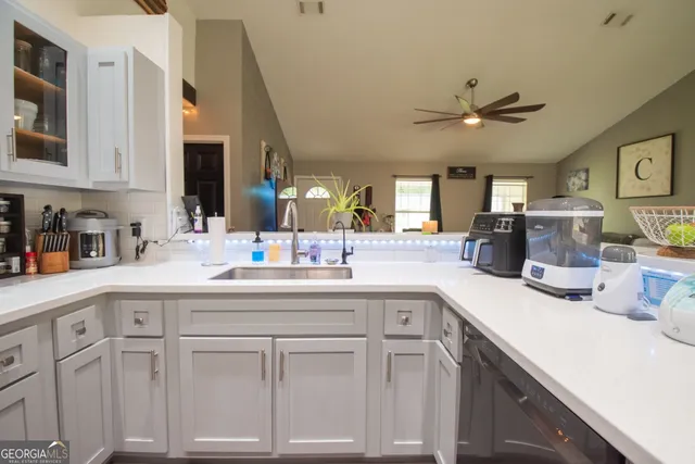 a kitchen with white cabinets and sink