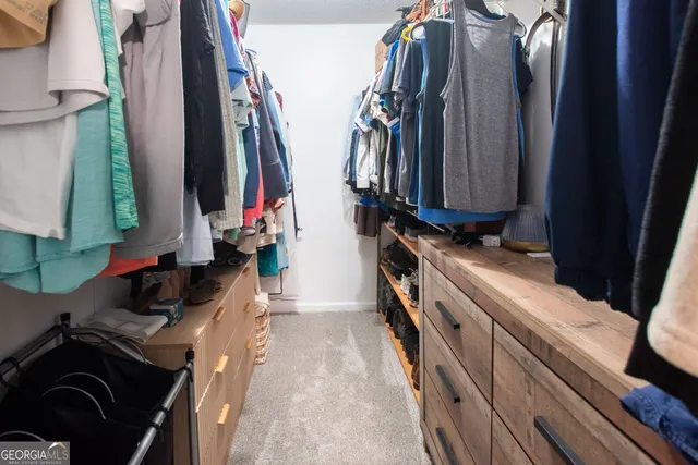 a view of walk in closet with clothes and shoes